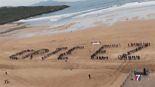 Trabajadores de Petronor forman un mosaico humano en la Playa de La Arena